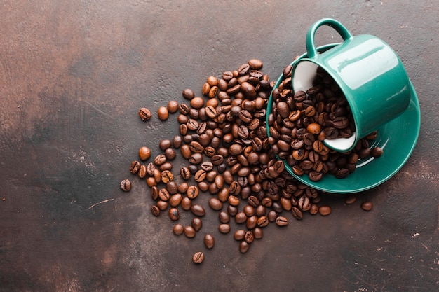 Cup spilled with coffee beans