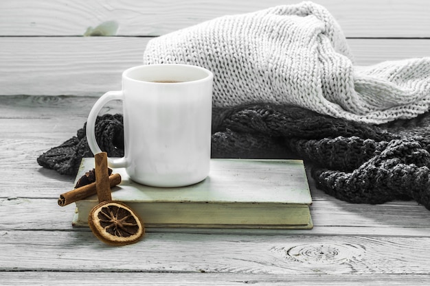 Free photo cup of tea on a beautiful wooden wall with winter sweater, old book