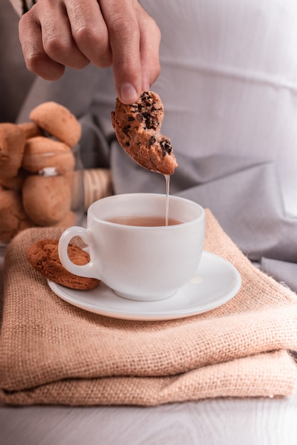 Free Photo cup of tea and biscuit with light background