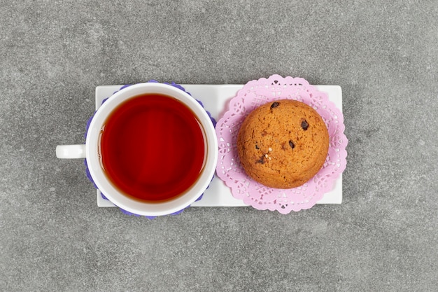 Free photo cup of tea and chip cookies on white saucer