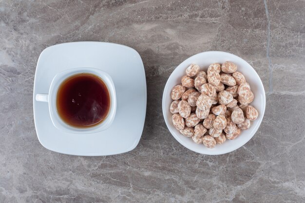 A cup of tea and confectionery on the marble surface