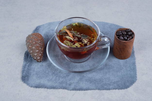 Cup of tea, pinecone and grains on marble background. High quality photo