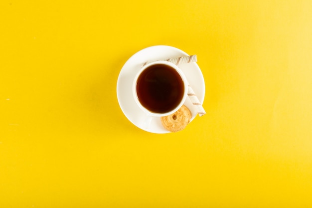 A cup of tea with biscuit . top view