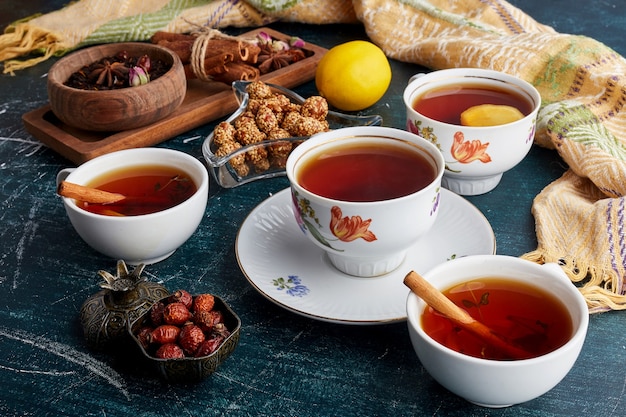 A cup of tea with fruits, sweets and spices.