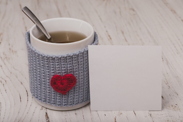 Free photo cup of tea with a heart with a white paper