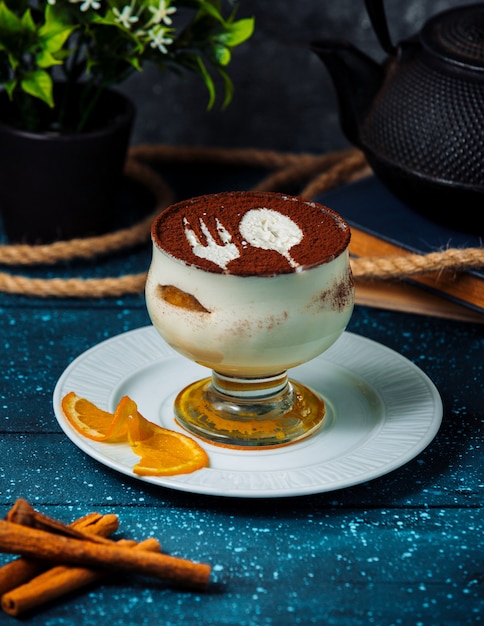 Free Photo cup tiramisu with cocoa powder and cinnamon sticks