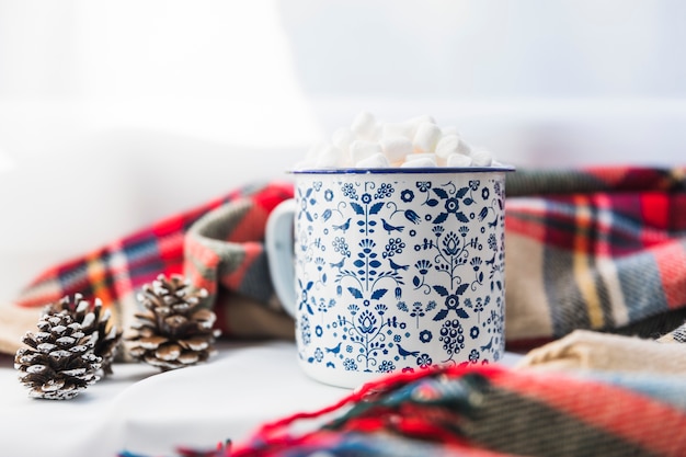 Free photo cup with marshmallow near scarf