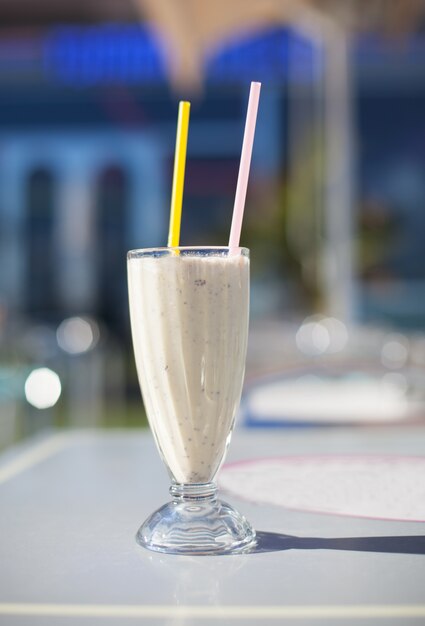 Cup with a smoothie with two straws