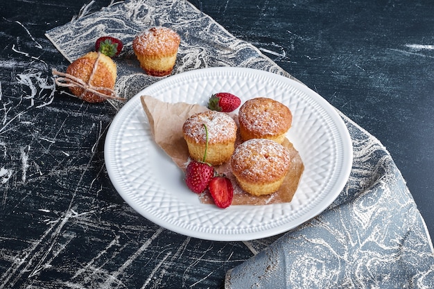 Free photo cupcakes in a white plate with berries.