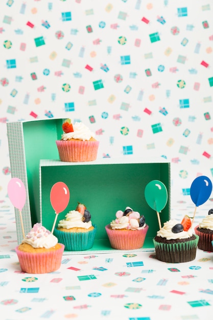 Cupcakes with balloon topping on table