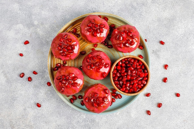 Cupcakes with pomegranate topping and seeds.