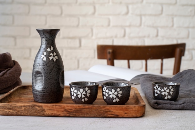 Cups and bottle on wooden board