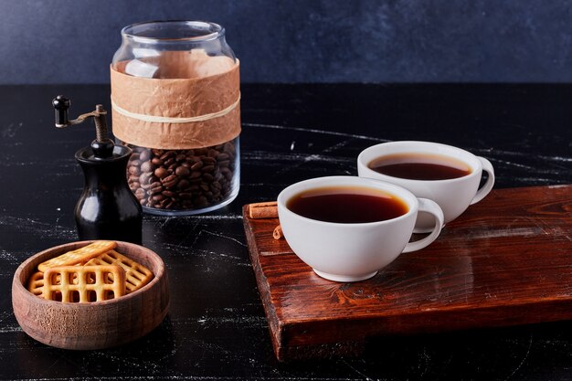 Cups of coffee with cookies and beans.