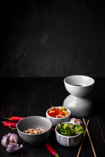 Cups with vegetables with peanuts and chopsticks