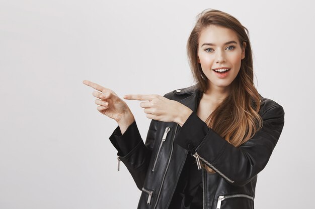 Curious attractive woman pointing left and asking question