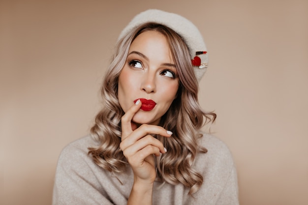 Curious well-dressed woman thinking about something with smile