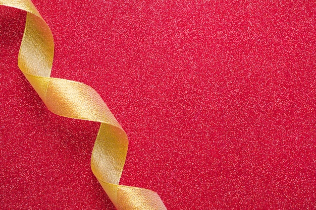 Curling ribbon crossing red background