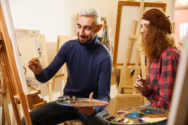 Free Photo curly girl and man draw a painting and smile