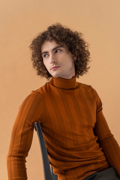 Free photo curly haired man with brown blouse posing