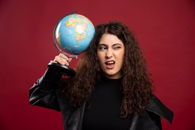 Curly woman holding globe.