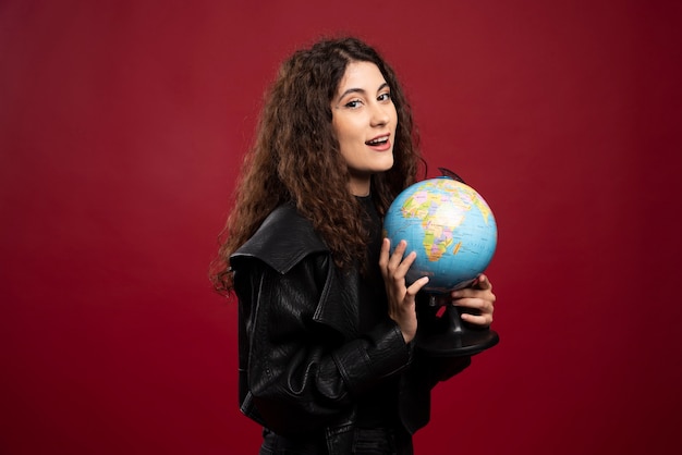 Free Photo curly woman posing with globe.