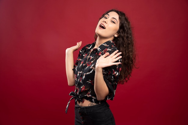 Curly woman with black blouse standing.