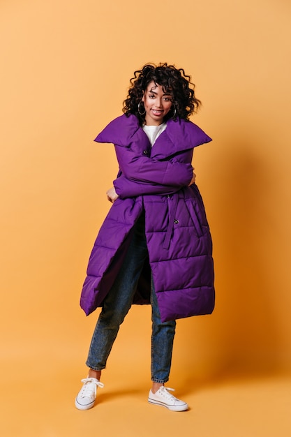 Free Photo curly young woman in white gumshoes looking at front