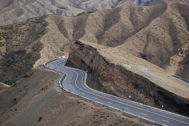 Curvy road around the cliff with mountains