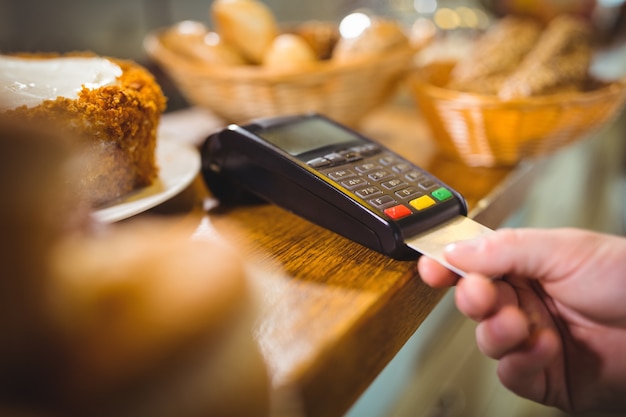 Customer making payment through payment terminal at counter