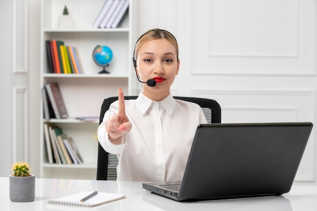 Customer service cute beautiful girl in white shirt with computer and headset showing stop sign