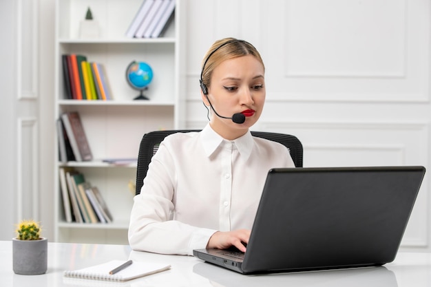 Customer service cute beautiful girl in white shirt with computer and headset typing