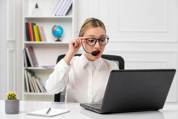 Customer service cute beautiful girl in white shirt with computer and headset on the videocall