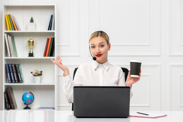 Free photo customer service cute blonde girl office shirt with headset and computer holding a coffee cup