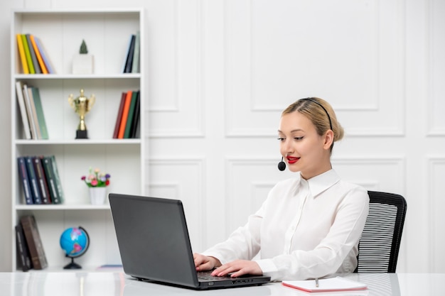 Customer service cute blonde girl office shirt with headset and computer typing on laptop