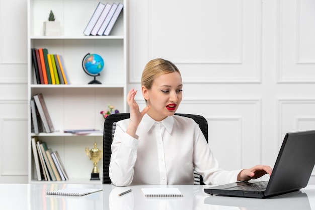 Customer service cute girl in white shirt with red lipstick and laptop irritated while working