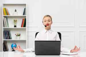 Free photo customer service cute woman in white shirt with headset and computer showing zen gesture