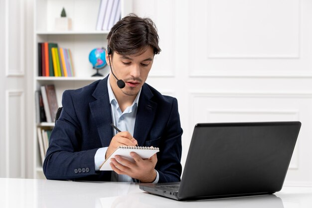 Customer service handsome guy with headset and laptop in suit taking down notes