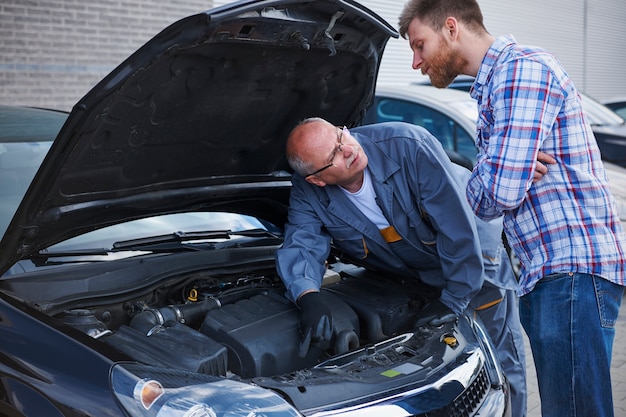 Free Photo customer talking with a mechanic in the workshop