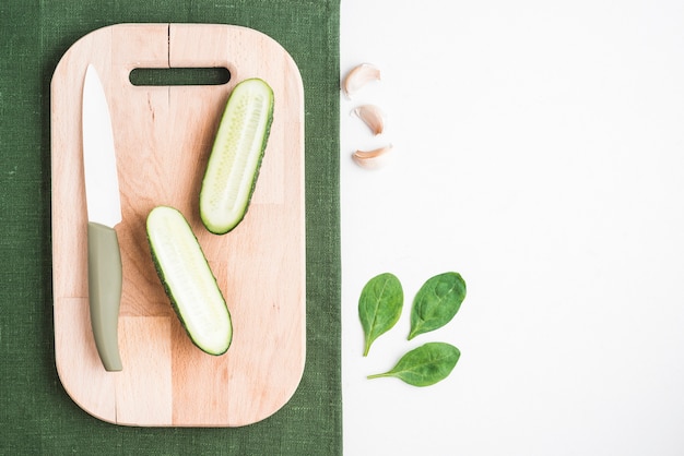 Free photo cut cucumber near spinach and garlic