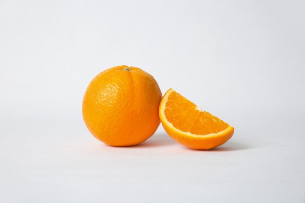 Cut orange section and whole fruit