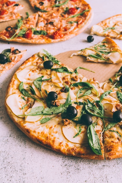 Cut pizzas on white table