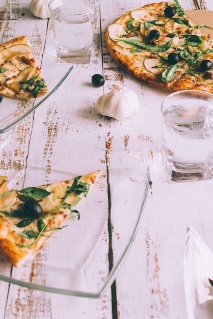 Cut pizzas on white table