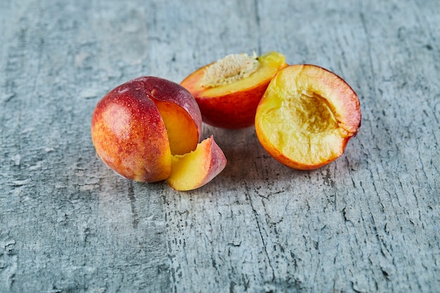 Free photo cut ripe nectarines on marble surface