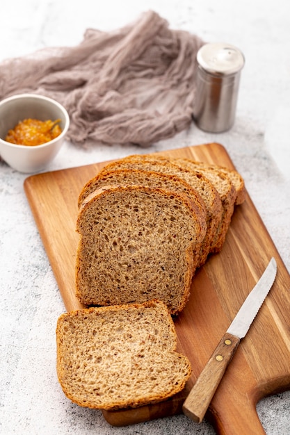 Cut slices of bread on wooden board with knife