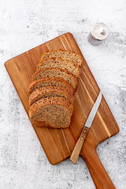 Free photo cut slices of wholemeal bread on wooden board