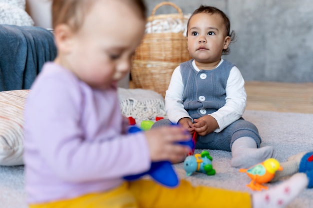 Free Photo cute babies playing on the floor with toys