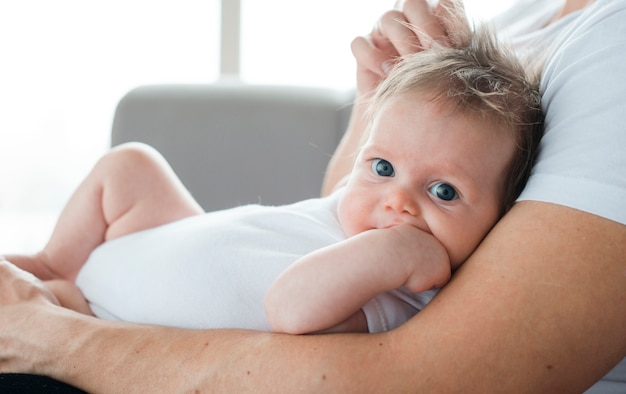 Free photo cute baby on father arms at home