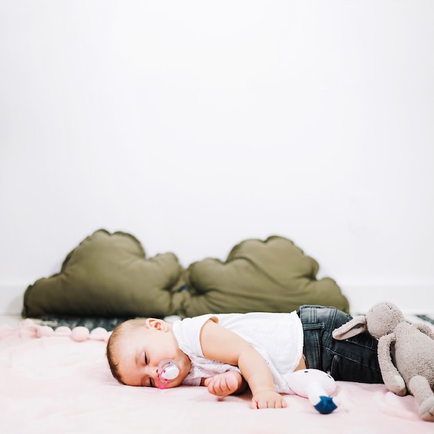 Free photo cute baby sleeping peacefully on nursery floor