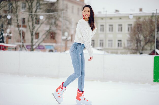 Cute and beautiful girl in a white sweater in a winter city