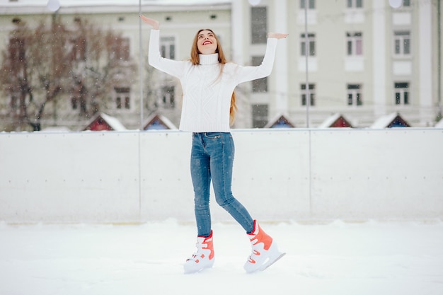 Cute and beautiful girl in a white sweater in a winter city